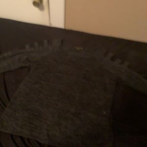 A dark gray sweater with cut out on the arms
